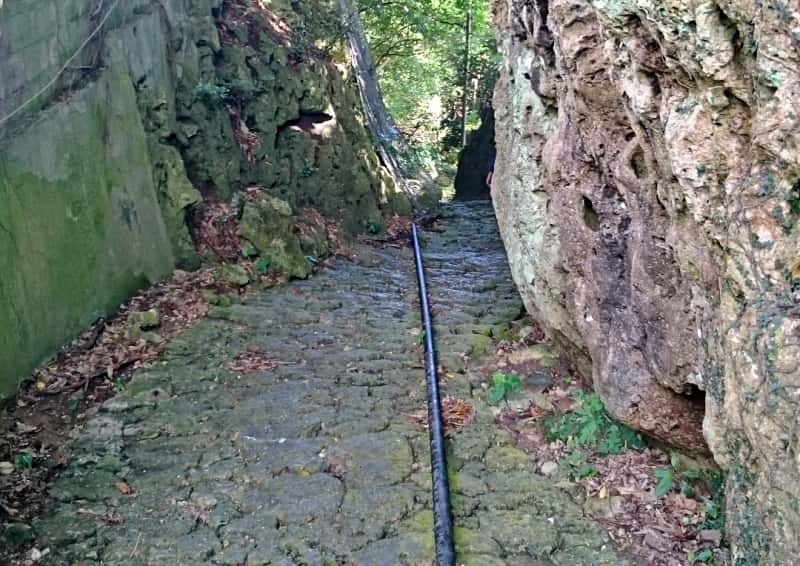 垣花樋川石畳の坂道下り。水道管が通っている